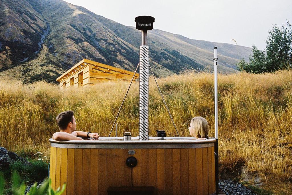 特威泽尔Te Manahuna Retreat的两人在田野的木制浴缸里