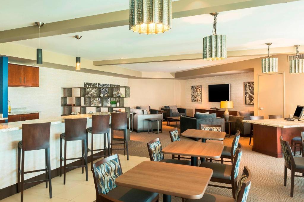 梅萨西格里维尔梅萨喜来登酒店的一间带桌椅的餐厅和一间酒吧