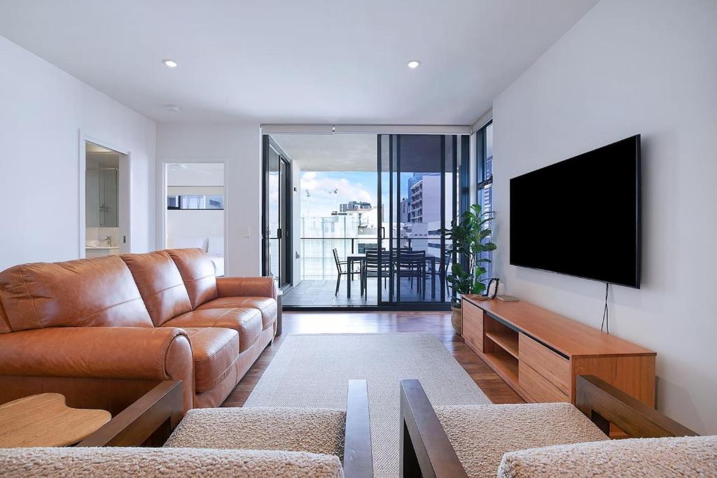 布里斯班Regatta Hideaway - A Breezy Balcony Residence的带沙发和平面电视的客厅