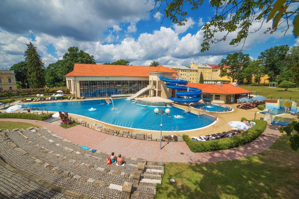 弗兰季谢克矿泉镇Spa Resort PAWLIK-AQUAFORUM的大楼前的大型游泳池