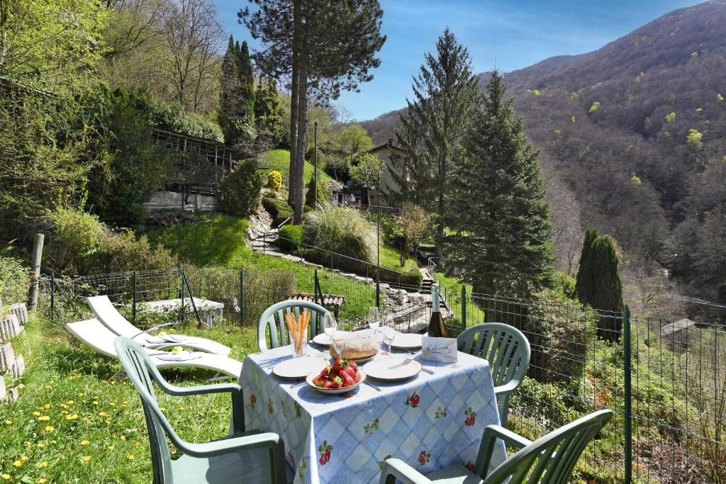 卢加诺Casa Lara - Happy Rentals的山丘上一张桌子,上面有白色的桌布和椅子