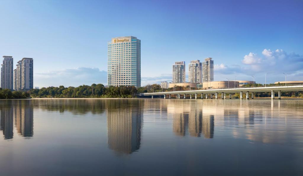 扬州扬州香格里拉酒店的一座拥有高楼和湖上桥梁的城市