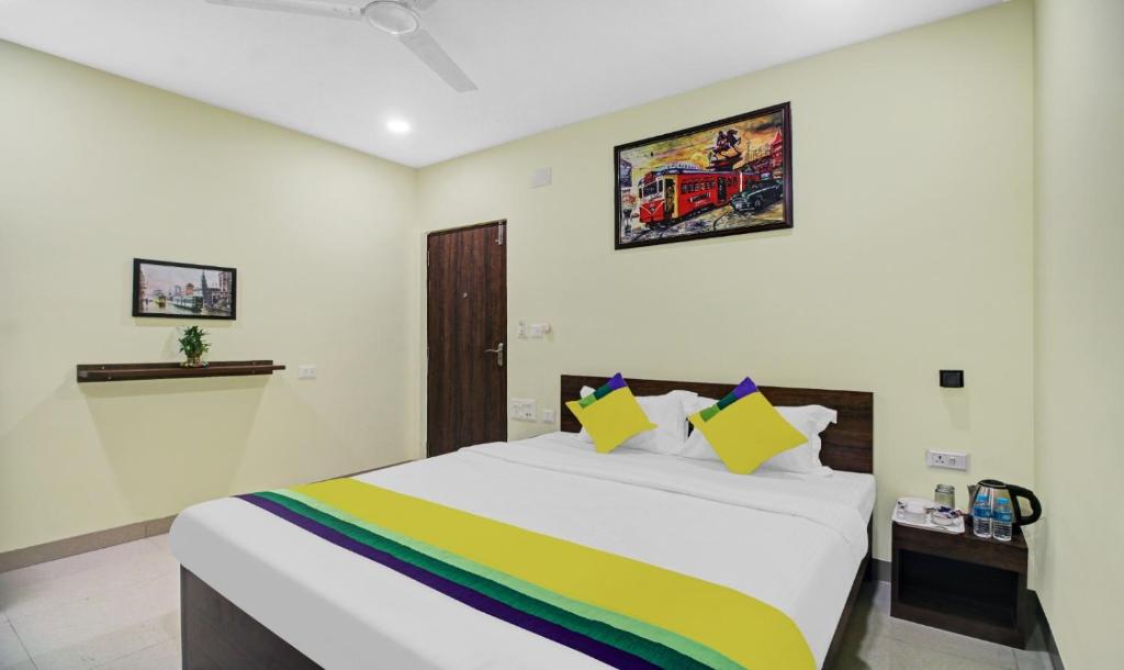 加尔各答Hotel Park Central的一间卧室配有一张大床和色彩缤纷的毯子