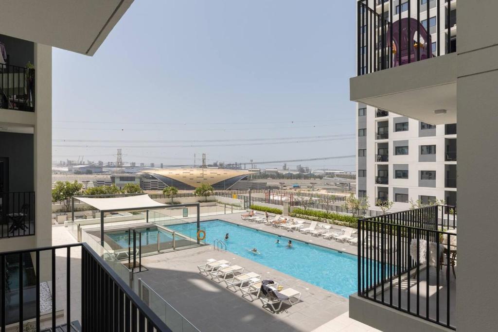 迪拜Comfortable 2bd Apartment Next To Metro & Mall的从大楼内可欣赏到游泳池的景色