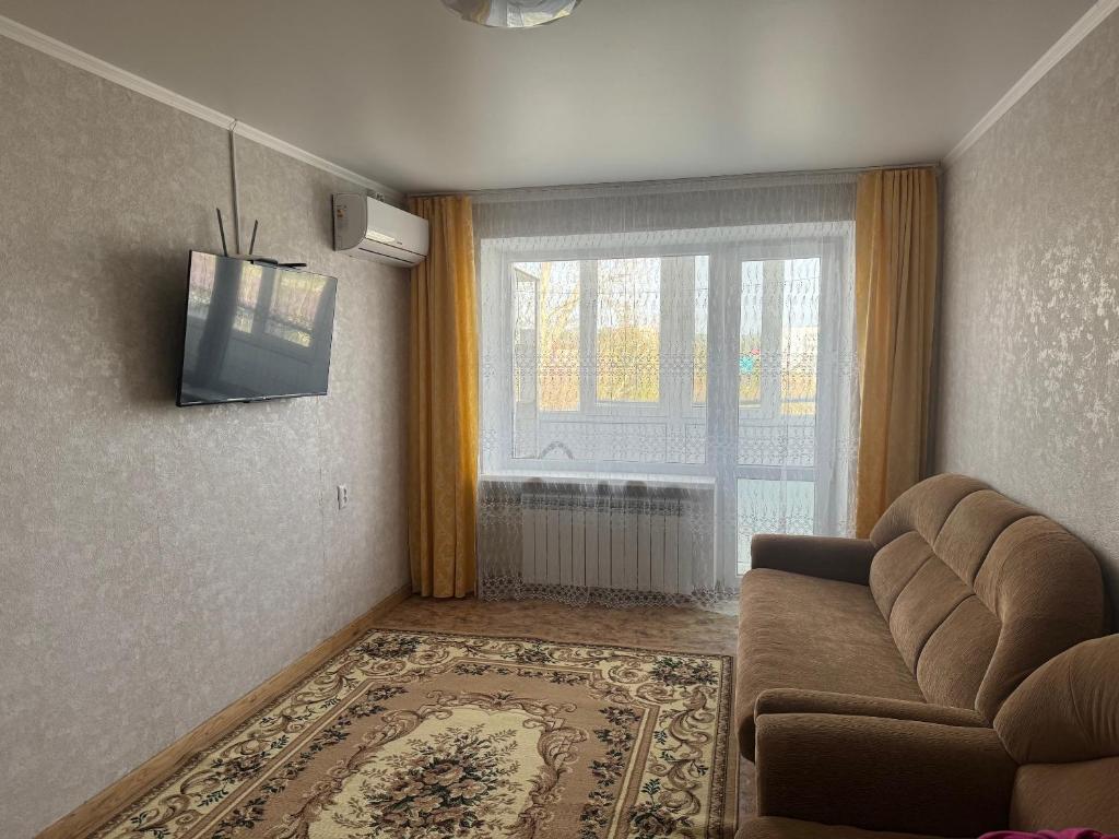 博罗沃耶Квартира улица Абая 18的带沙发和窗户的客厅
