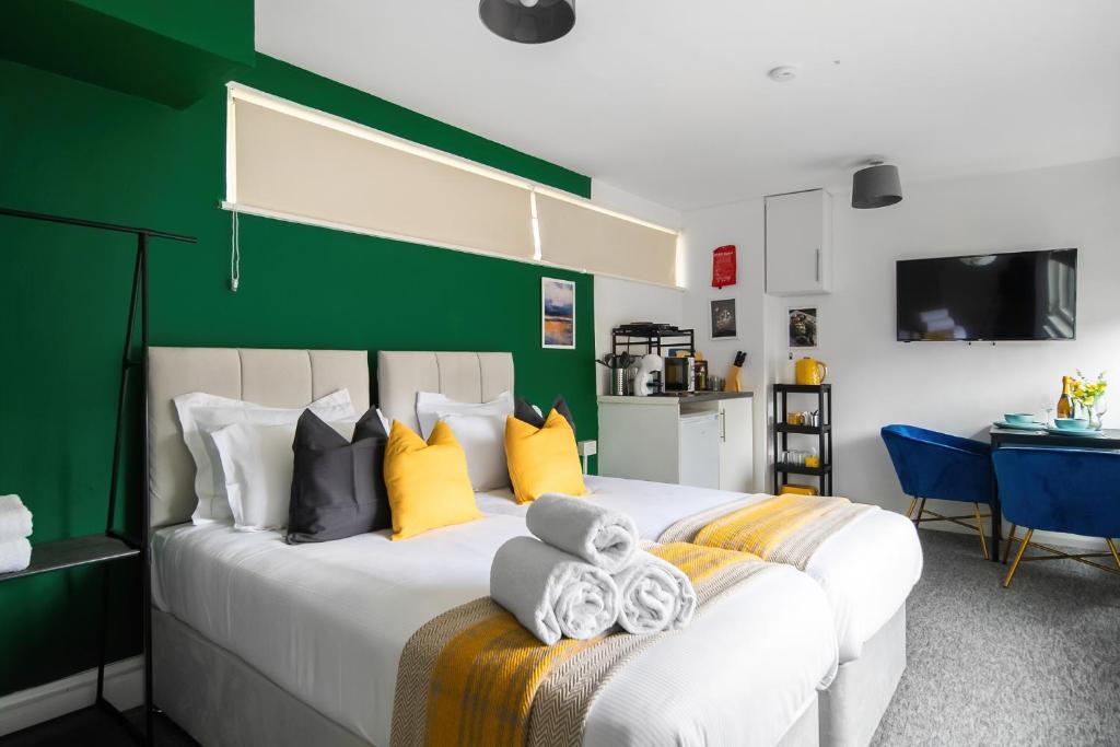 East BarnetLivestay Affordable En-Suite Studio Rooms in London, N14的一间卧室设有一张大床和绿色的墙壁