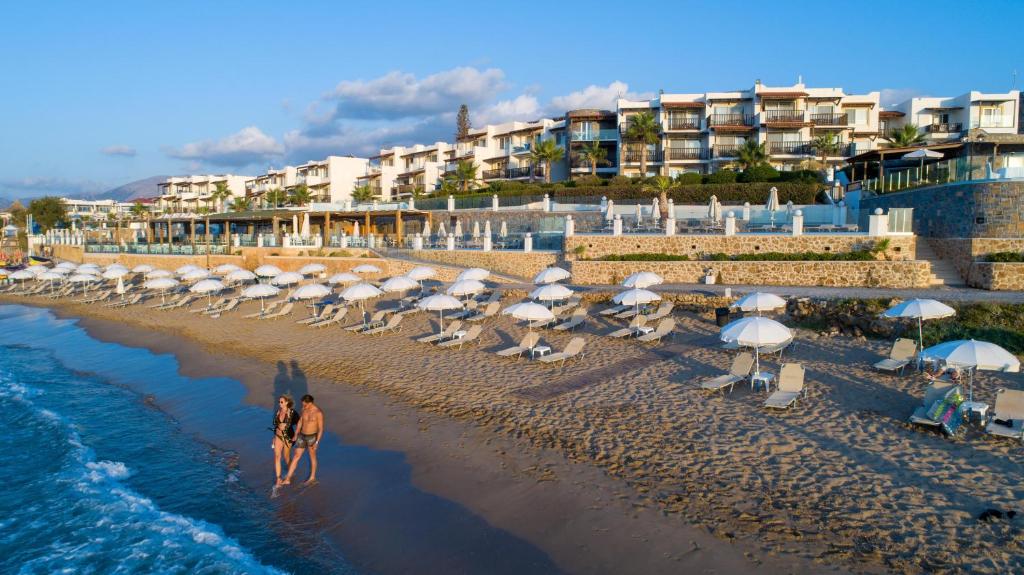 玛利亚Alexander Beach Hotel & Village Resort的海滩上,有一堆遮阳伞和人