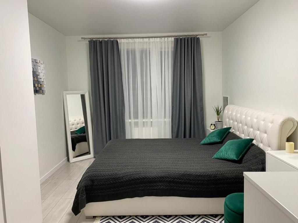 奥什A cosy apartment的一间卧室配有一张带绿色枕头的大床