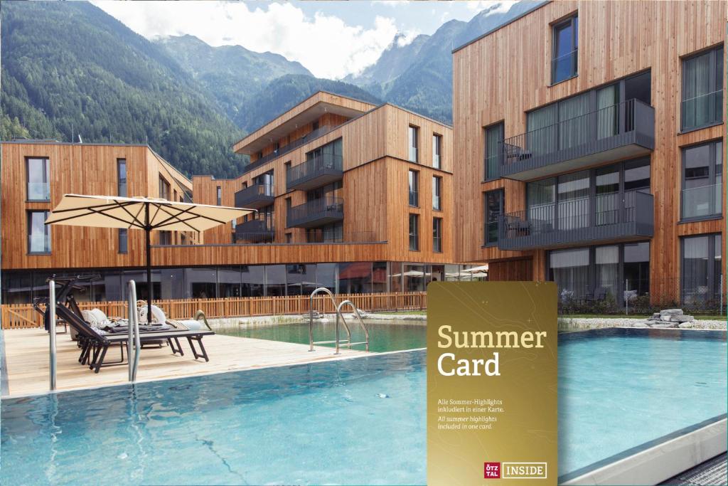 厄茨All-Suite Resort Ötztal的一座酒店,在一些建筑前设有一个游泳池