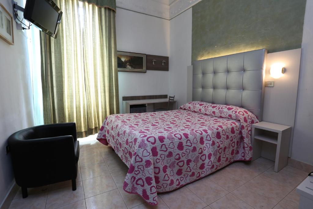 米兰皮奥拉酒店的卧室配有粉红色的床和椅子