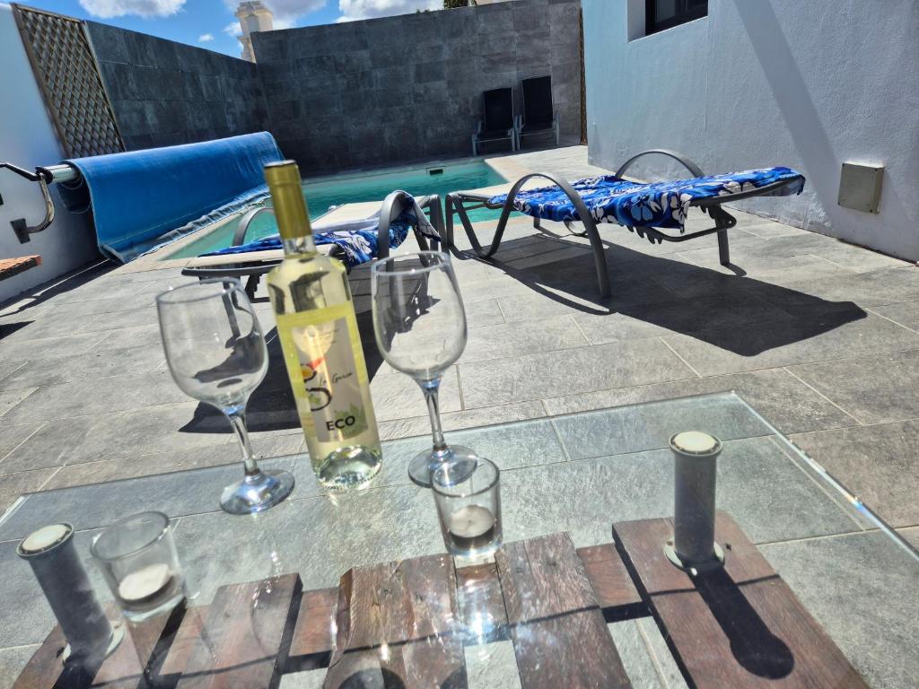 卡门港villa del mar puerto del carmen的一张桌子,上面放着眼镜和一瓶葡萄酒