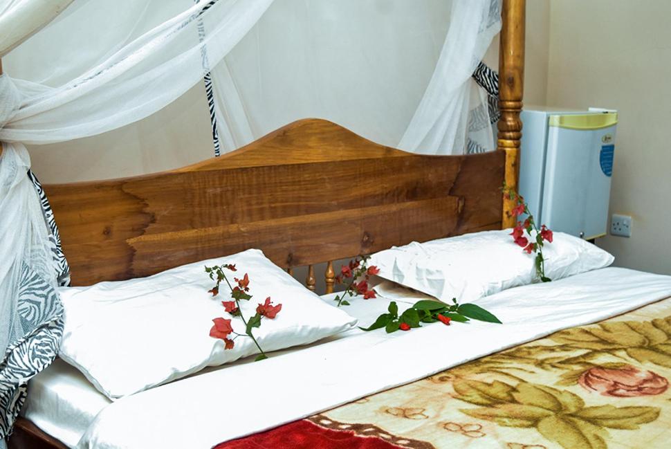 卡拉图KLH REST HOUSE的两张带白色床单和鲜花的床