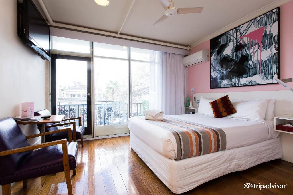 墨尔本Tolarno Hotel - The Philippe - Australia的一间卧室配有一张床、一张书桌和一个窗户。