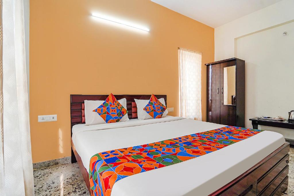 蒂鲁帕蒂FabHotel S V Homestay Tirupati的一间卧室配有一张大床和色彩缤纷的毯子