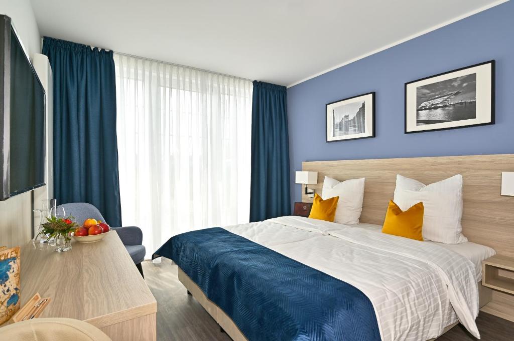 韦德尔HotelHafenWedel的一间卧室配有一张大床,拥有蓝色的墙壁和黄色的枕头