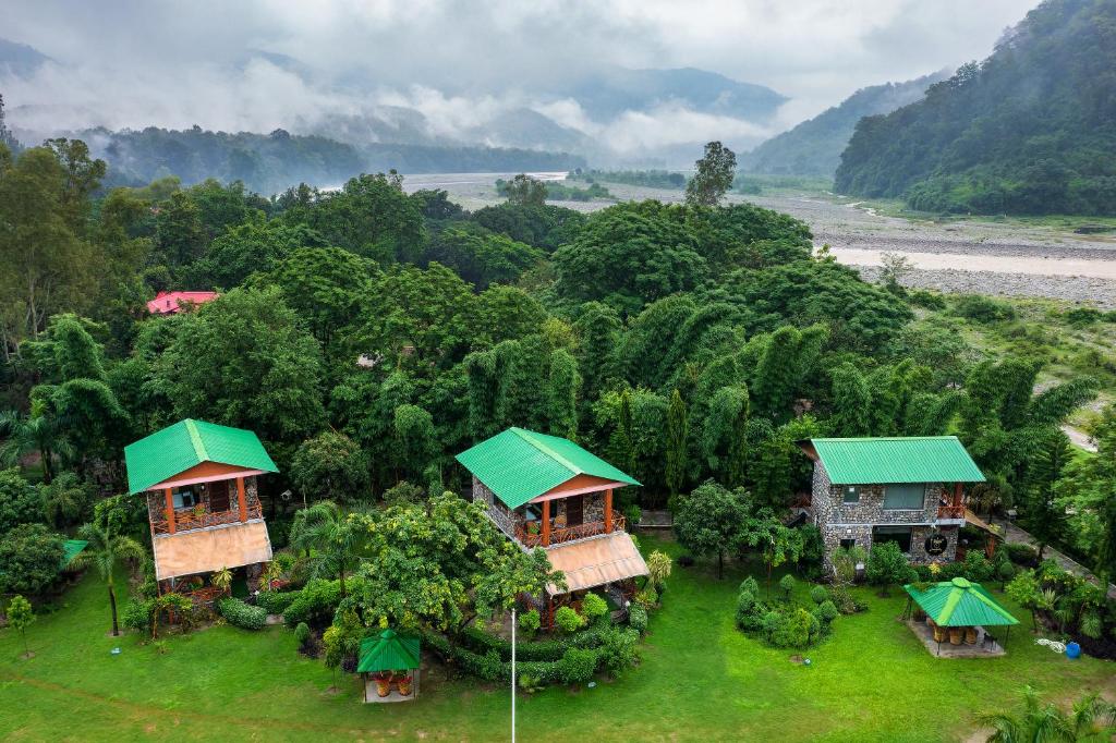 MarchulaTashree Kabeela Riverside Resort的两栋带绿色屋顶的房屋的空中景致