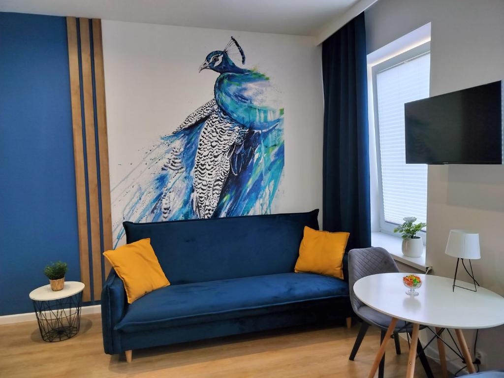 帕比亚尼采STUDIO BLUE BIRD PIĘKNA 2 wejście na kod CENTRUM的客厅里一张蓝色的沙发,墙上挂着一幅画