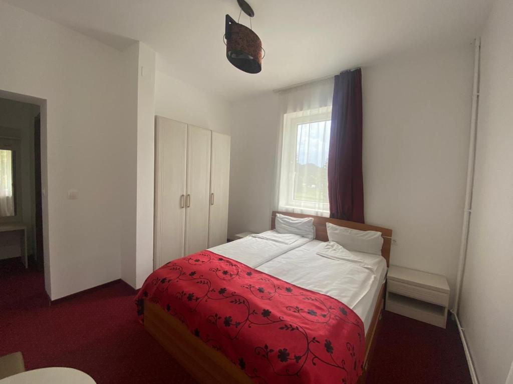 波亚纳布拉索夫Casa Verde Poiana Brasov的一间卧室配有一张带红色毯子的床