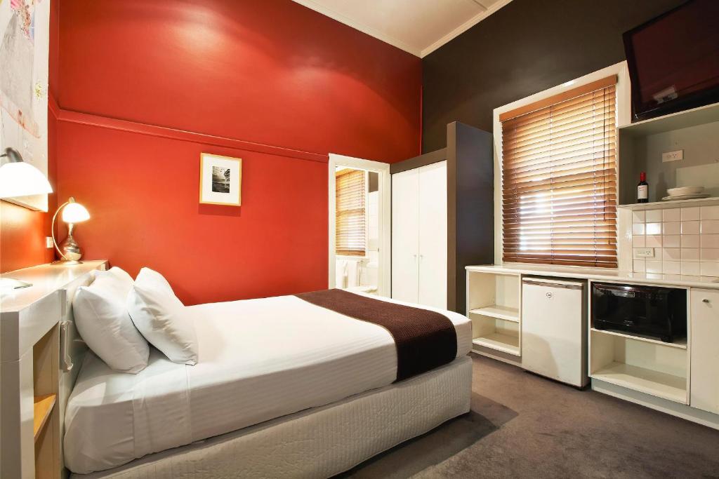墨尔本Tolarno Hotel - Balazac Room - Australia的红色卧室设有床和水槽