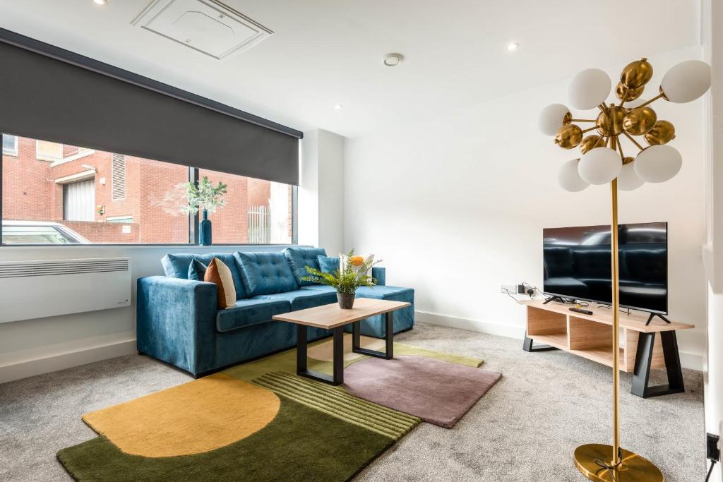 罗瑟勒姆Modern Studio Apartment in Central Rotherham的客厅配有蓝色的沙发和电视