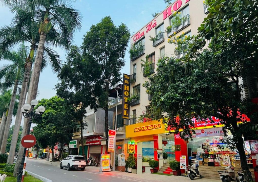 Uông BíThu Ha Hotel的城市街道上的一座建筑,汽车驶过