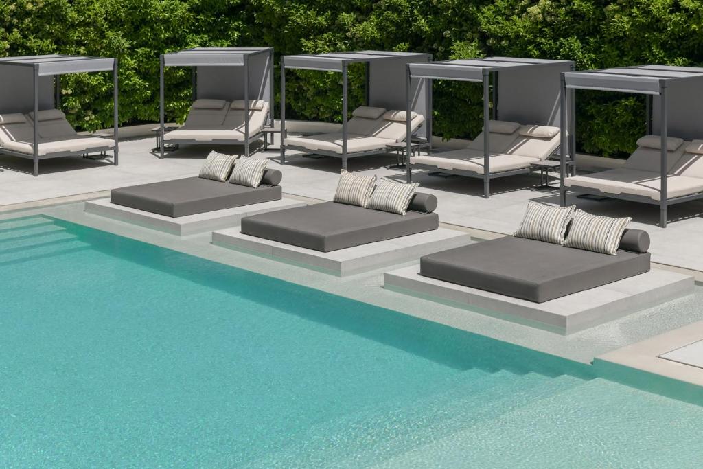 雅典布雷泽套房酒店的一组躺椅,位于游泳池旁