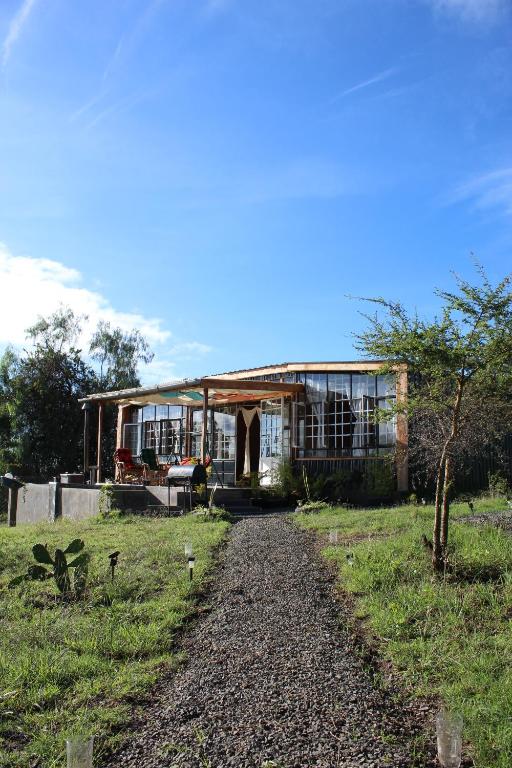 纳库鲁The Cascades Cabin Nakuru的前面有一条碎石路的房子