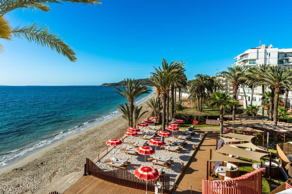 普拉亚登博萨Hotel Vibra Algarb的海滩上设有椅子和遮阳伞,还有大海