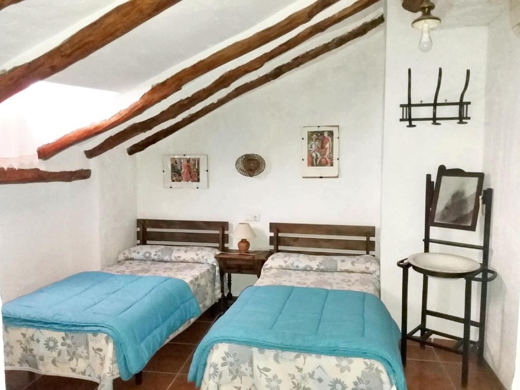 克萨达6 bedrooms house with balcony at Quesada的一间卧室配有两张床、一张桌子和一把椅子