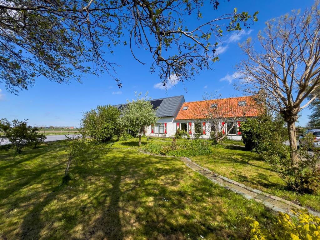 赫鲁德Het Zoete Pèèrd的绿色田野上一座带橙色屋顶的房子