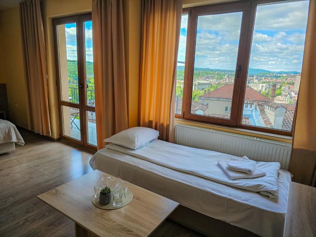 大特尔诺沃Family Hotel "Slavianska dusha"的客房设有床、桌子和窗户。