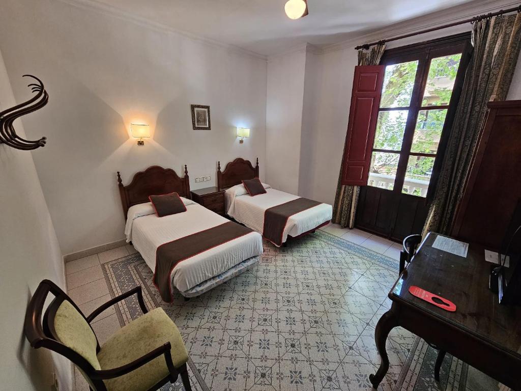 兰哈龙Hotel España的酒店客房配有两张床和一张书桌