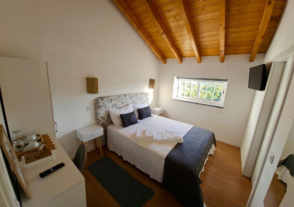 塞卡尔Casa do Chafariz - Rooms的一间卧室设有一张床和一个窗口
