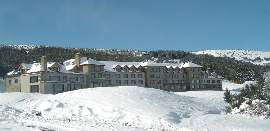 圣马丁德洛斯夏佩克套房酒店的山前大雪覆盖的建筑