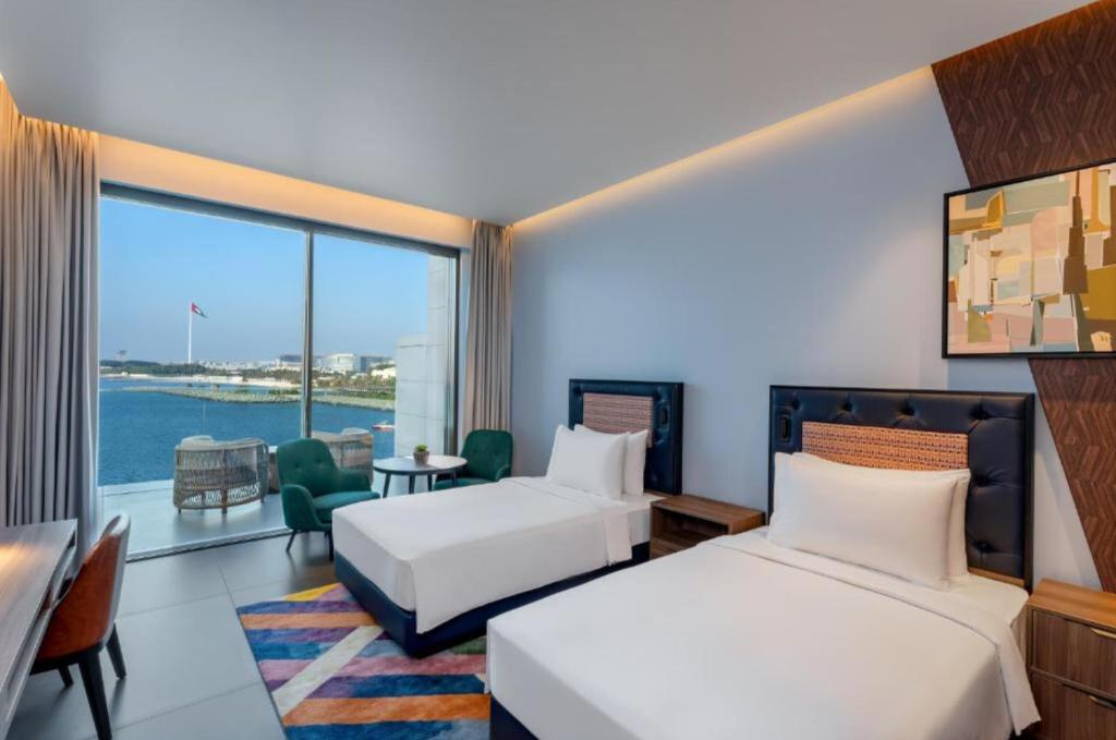 迪拜Hyatt Centric Jumeirah - Twin Room Sea View - UAE的酒店客房设有两张床和大窗户。