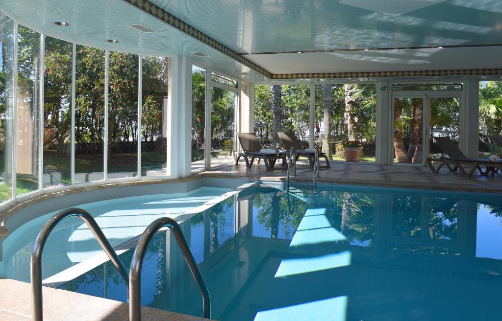 巴斯蒂亚Ostella Spa & Resort的玻璃墙房子内的游泳池
