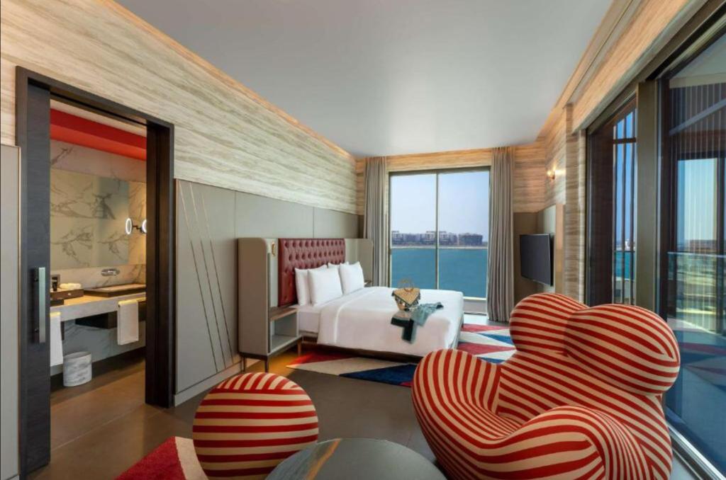 迪拜Hyatt Centric Jumeirah Dubai - Deluxe Room - UAE的酒店客房配有一张床、一张沙发和椅子。