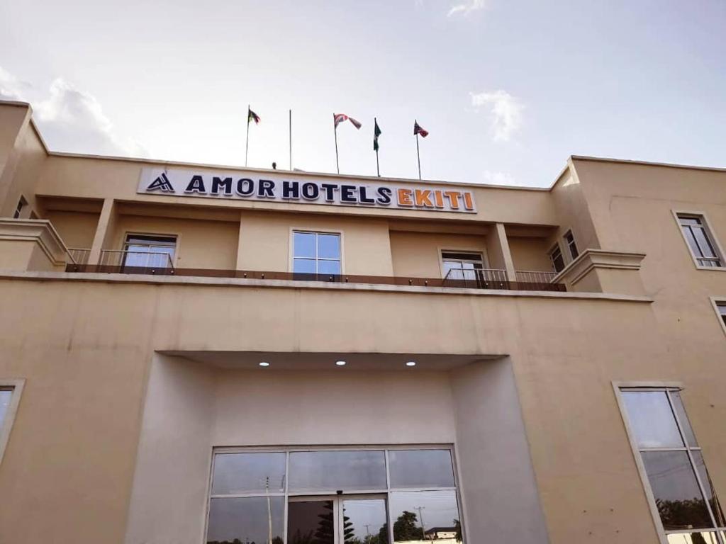 Ado EkitiAMOR Hotel Ekiti的上面有旗帜的迫击炮酒店