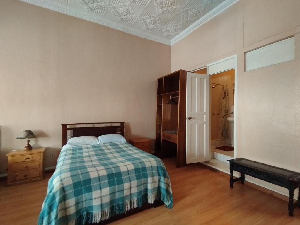 拉塔昆加Hotel Rosim Cotopaxi的一间卧室配有一张带 ⁇ 子毯子的床