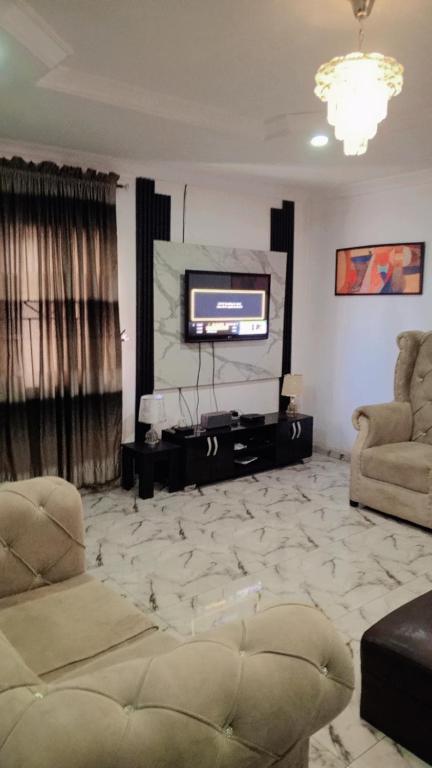 IkoroduJ Lounge的带沙发和电视的客厅