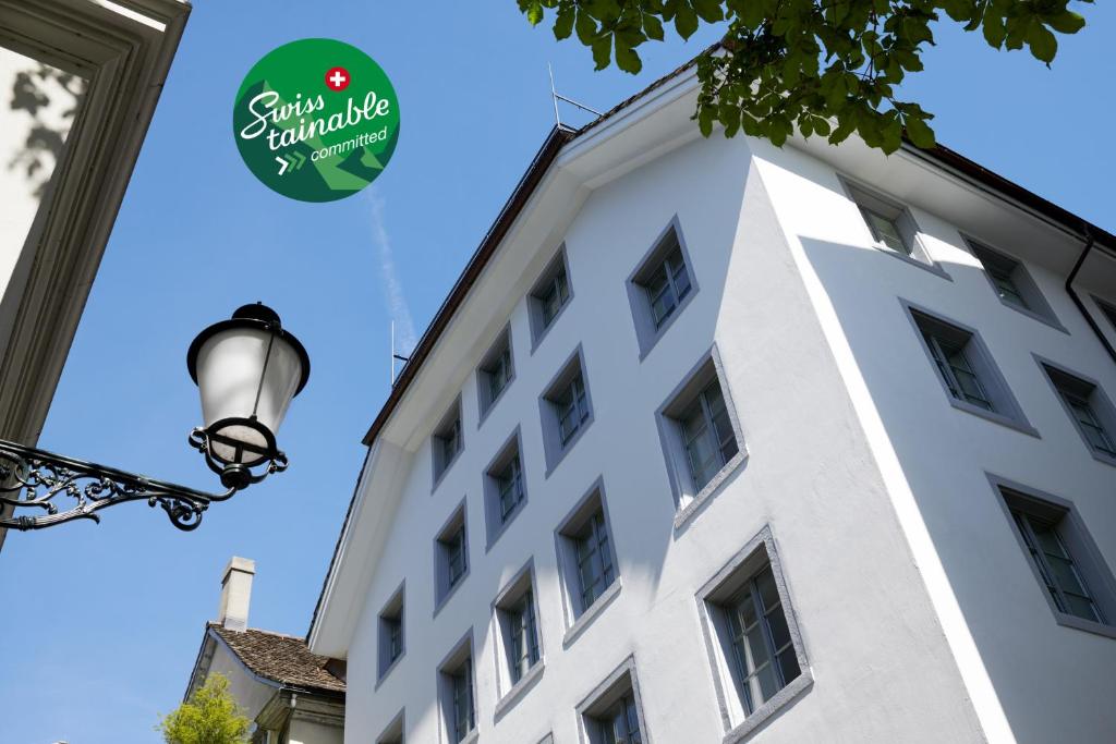 苏黎世Boutique Hotel Helmhaus Zürich的白色的建筑,上面有标志