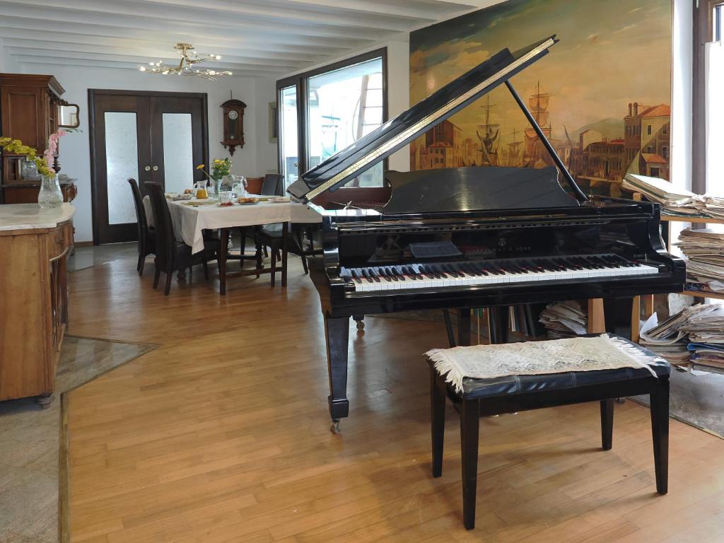 的里雅斯特达乐拉住宿加早餐旅馆的一间设有桌子和用餐室的钢琴