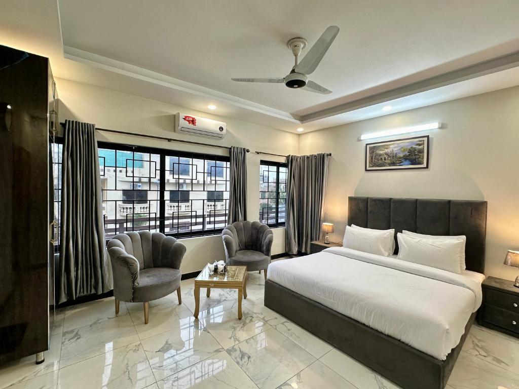 伊斯兰堡Dream Executive Guest House的酒店客房,配有一张床和两把椅子