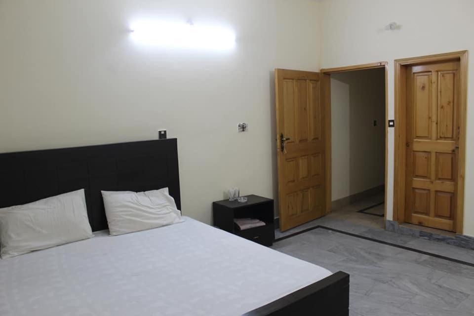 穆扎法拉巴德Kashmir Inn Hotel的一间卧室设有一张床和一个开放式门