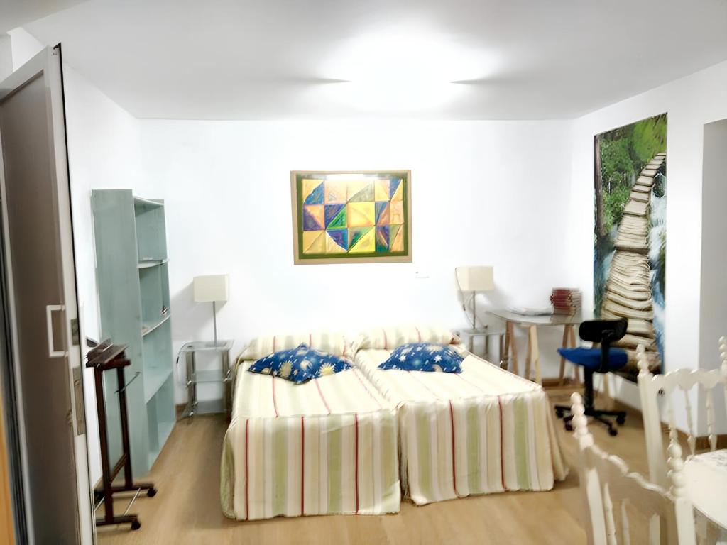 布尔戈斯4 bedrooms house with city view and terrace at Burgos的一间卧室配有一张带蓝色枕头的床。