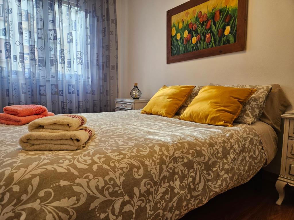 希洪Casa Lantoxana 1A121的一间卧室配有一张带黄色枕头的床和一幅画