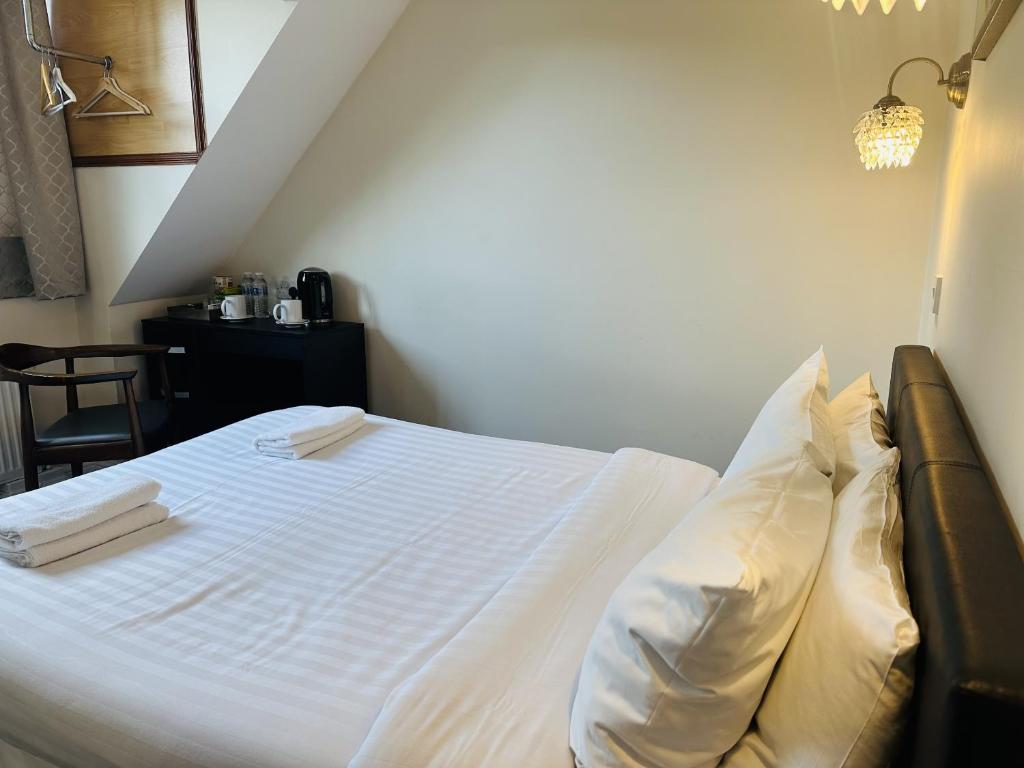 菲尔布里奇woodcock inn的一间卧室配有带白色床单和枕头的床。