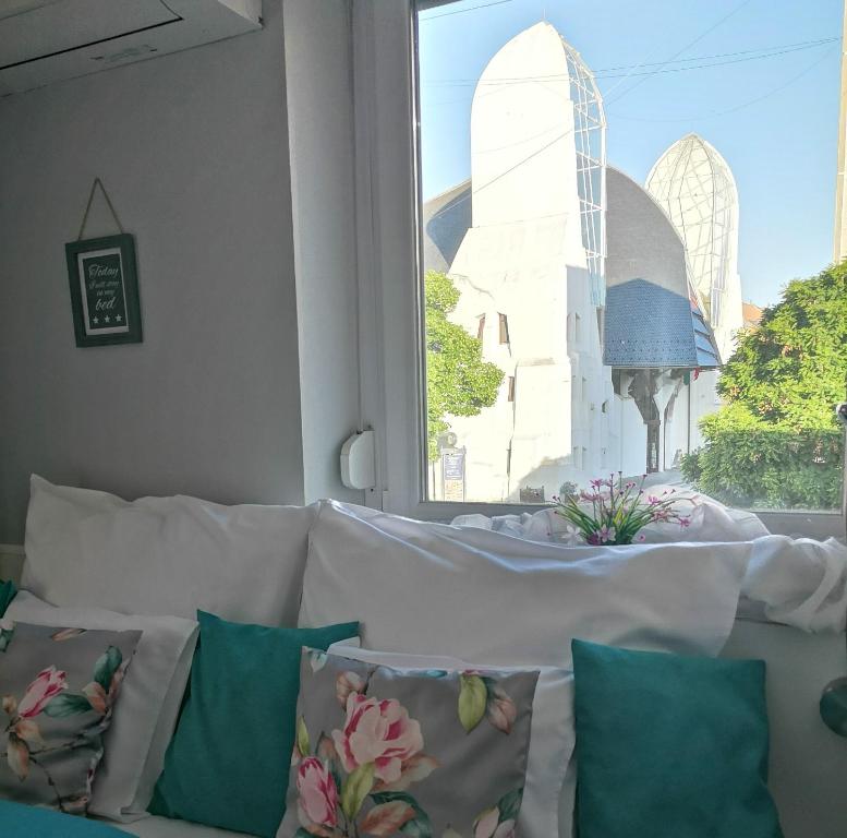 毛科Centrum Luxus Apartman的窗户前配有带枕头的白色沙发