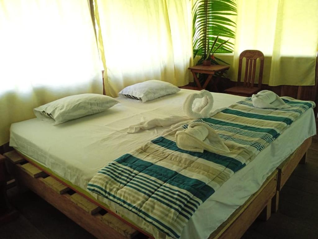 NautaAmazon Jungle Reps的床上配有毛巾和枕头