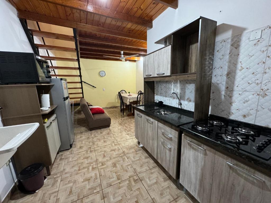 伊瓜苏港Adhara Apart的厨房配有木制橱柜和炉灶烤箱。